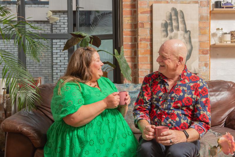 Two people talking on a couch.